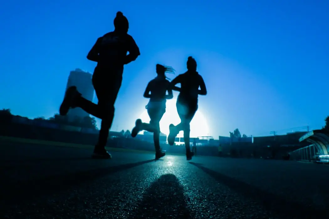 Silhouette of runners at night.
