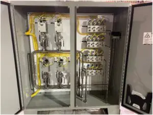 Picture1 A gray electrical control panel with an open door shows neatly arranged yellow wires, metal pipes, switches, and terminal blocks inside, displaying a well-organized industrial wiring setup.