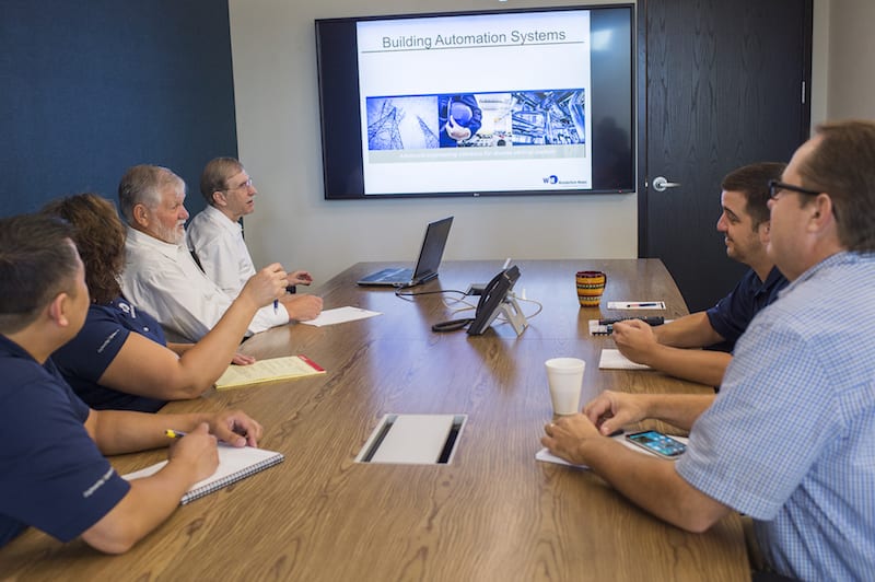 final-0490-2 Employees having a team meeting around a conference table.