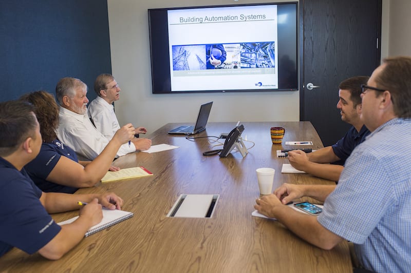 Employees having a team meeting around a conference table.