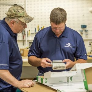 Two Wunderlich-Malec employees working on a piece of equipment.
